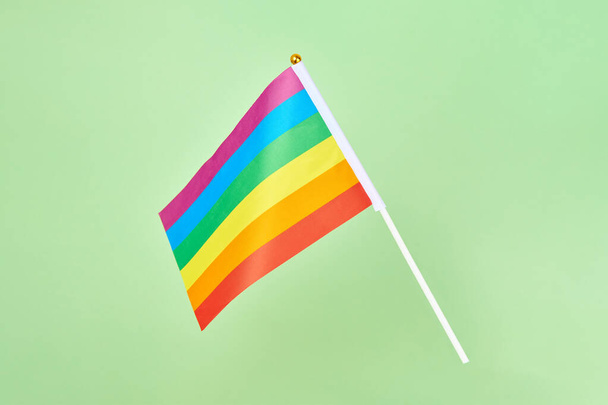 Bandera arco iris del movimiento LGBT símbolo. Bandera de la comunidad LGBT, lesbiana gay bisexual transgénero y orgullo queer sobre fondo verde, colores del espectro de la sexualidad humana y género - Foto, imagen