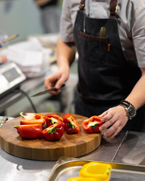 the chef cuts the red bell pepper - Valokuva, kuva