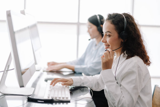 secretary operator wears a headset and microphone for consultant assistance support, the call center staff providing advice and assistance customers in smiling and happy manner  - 写真・画像