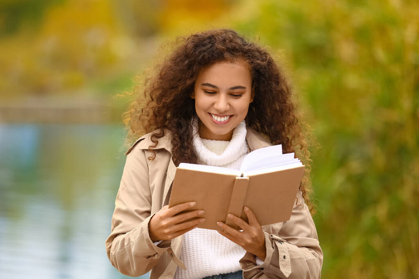 Mulher afro-americana atraente ler livro ao ar livre - Foto, Imagem