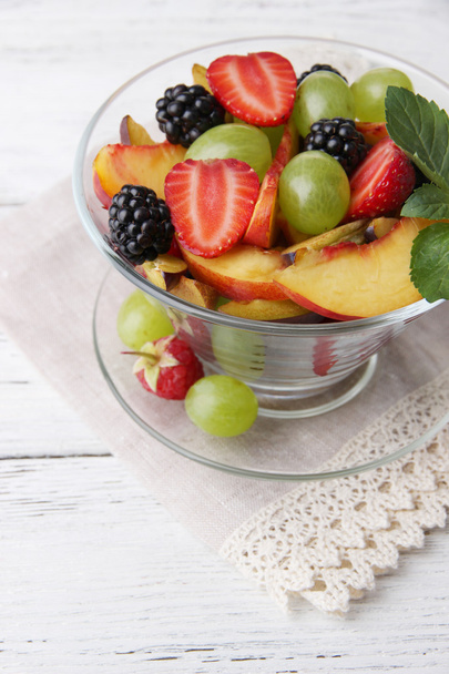 салат из свежих фруктов на деревянном столе
 - Фото, изображение