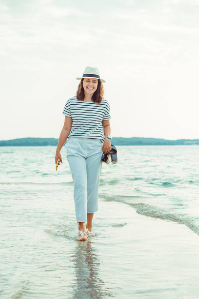 woman in white clothes walking by sea beach summer time - Photo, Image