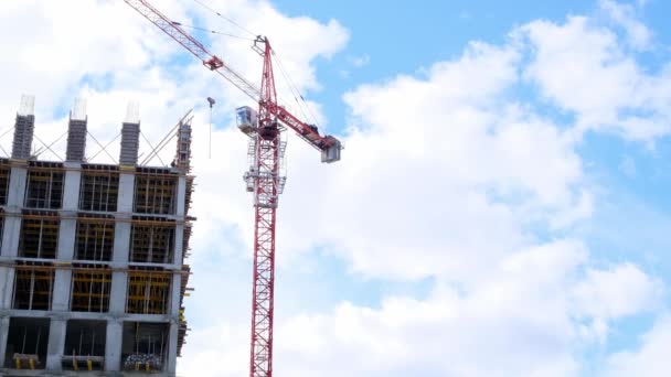 Construction industry. High rise building under construction and construction crane up to the sky. Housing construction, apartment building in the city, mortgage - Footage, Video