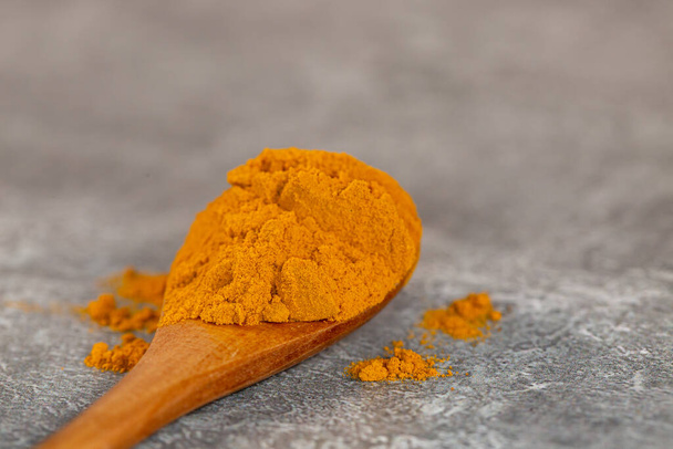 A close up of a spoonful of powdered turmeric, with a shallow depth of field - Фото, зображення