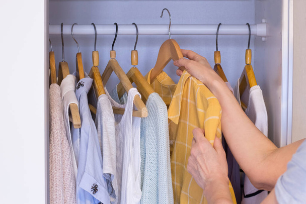Clothes on hangers in wardrobe - Фото, зображення