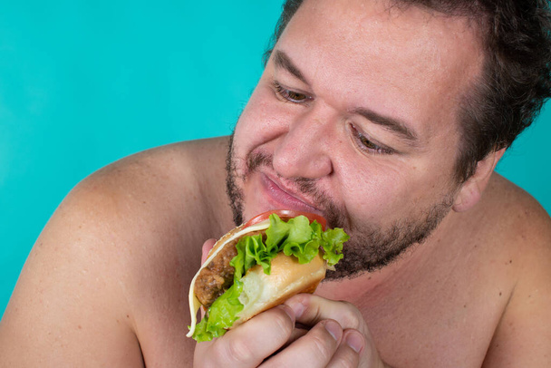 食事と健康的なライフスタイル。変な太った男だ。青の背景. - 写真・画像