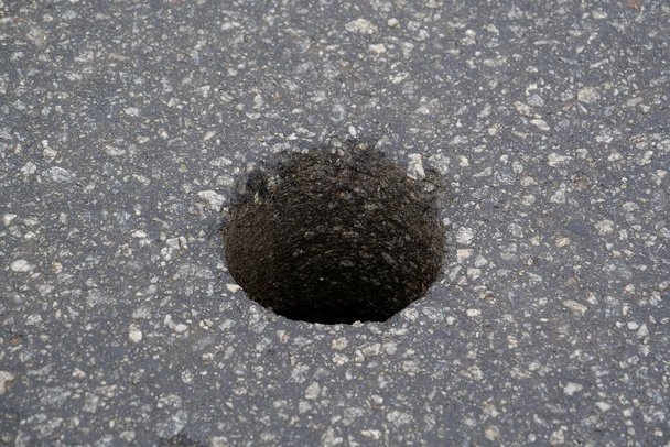 Trou rond dans l'asphalte pour vérifier la qualité de la chaussée - Photo, image