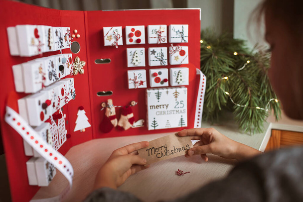 Bella ragazza tiene calendario dell'avvento originale fatto di portagioie e raccoglitore, mestiere fai da te di Natale - Foto, immagini