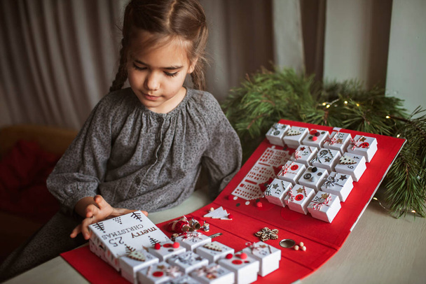 Menina bonita detém calendário de advento original feito de caixas de jóias e aglutinante, Natal artesanato diy - Foto, Imagem