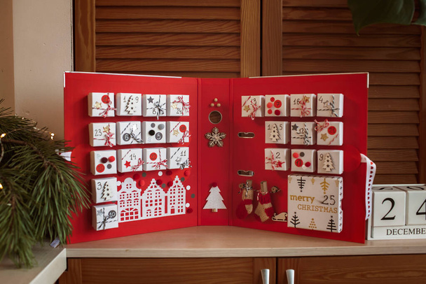 Pretty girl sostiene el calendario de adviento original hecho de cajas de joyería y carpeta, artesanía de Navidad bricolaje - Foto, Imagen