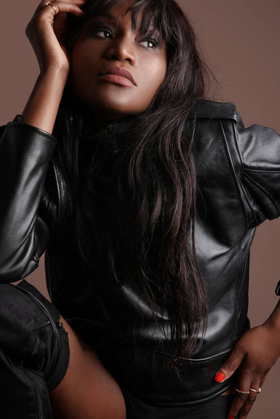 Vertical shot of attractive black young woman with long hair wears jacket. - 写真・画像