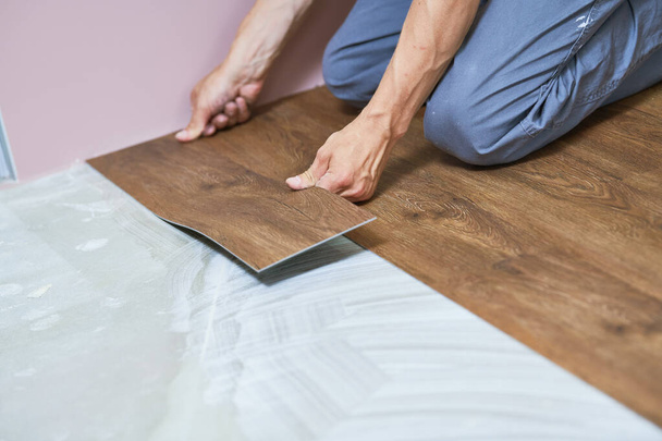 worker joining vinyl floor covering at home renovation - Photo, Image