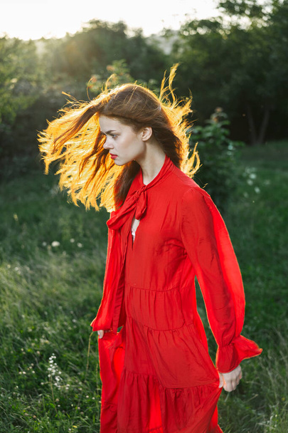 attractive woman in red dress outdoors in freedom field - Valokuva, kuva