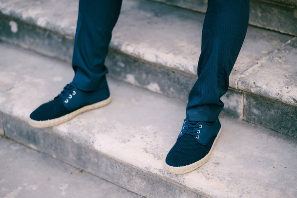Groom feet in trousers and sneakers on stone steps - Photo, Image