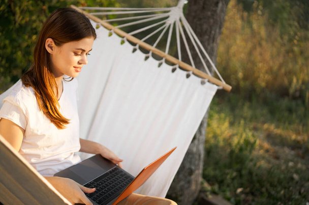 woman working on laptop in nature hammock freelance - Foto, imagen
