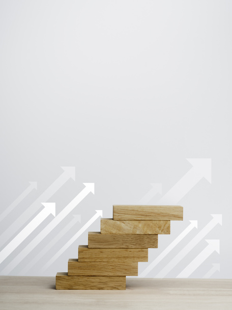 White rise up arrows with wooden blocks arranged as a steps chart on a wooden desk and clean white background with copy space, vertical style. Business growth process and economic improvement concept. - Zdjęcie, obraz