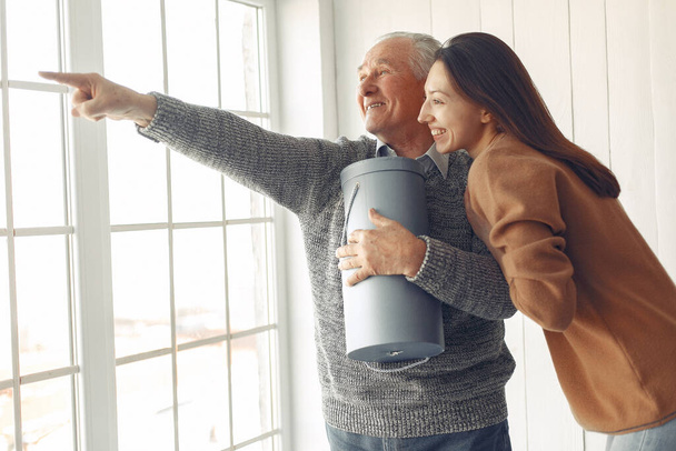 Elegant old man standing at home with his granddaughter - Φωτογραφία, εικόνα