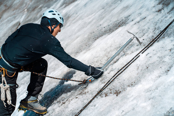 Homme avec piolet sur le glacier. - Photo, image