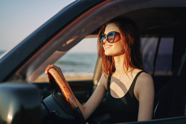 pretty woman in sunglasses driving a car trip - Foto, afbeelding