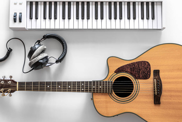 Ακουστική κιθάρα και μουσικά πλήκτρα σε λευκό φόντο, επίπεδη lay. - Φωτογραφία, εικόνα