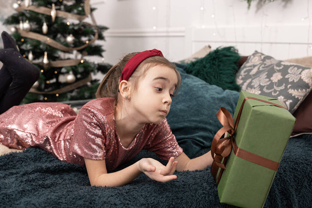 Petite fille drôle avec une boîte cadeau de Noël. - Photo, image