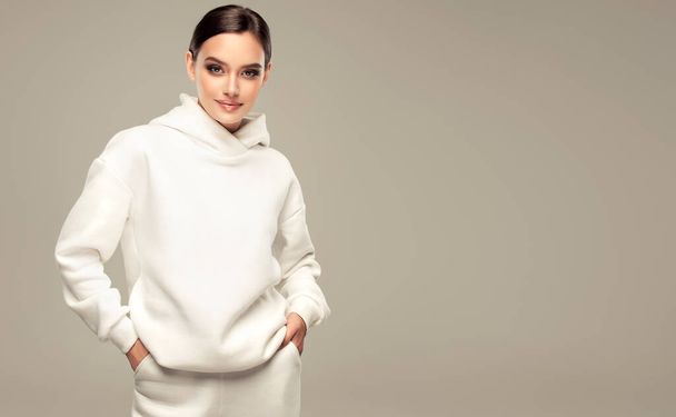 trendi meleg tél - gyönyörű fiatal nő fehér kapucnis - Fotó, kép