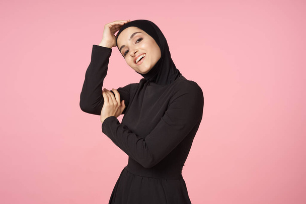 cheerful muslim woman black hijab posing hand gesture pink background - Fotó, kép