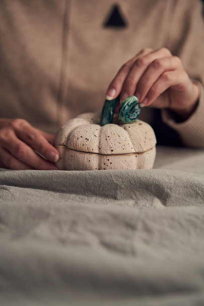 Crop female with handmade ceramic pumpkin - Foto, imagen