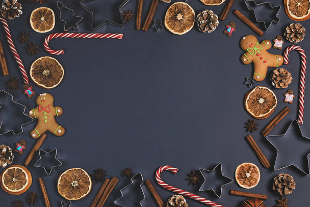 Christmas food border frame. Gingerbread cookies, spices and decorations on dark background. - Valokuva, kuva