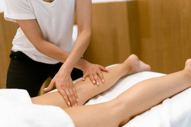 Middle-aged woman having a leg massage in a beauty salon. - Zdjęcie, obraz