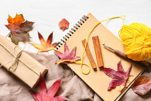 Composición con hojas de otoño, hilo de punto y caja de regalo sobre fondo de madera claro, primer plano - Foto, imagen