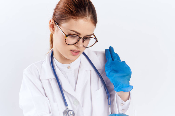 medico donna seduto a tavola con guanti blu test farmacologici - Foto, immagini