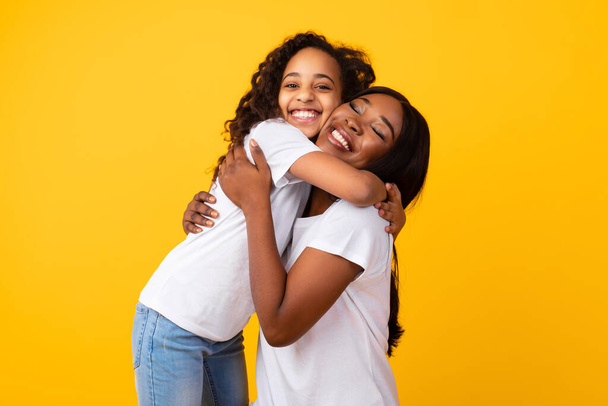 アフリカ系アメリカ人の女の子抱擁彼女の笑顔お母さんにスタジオ - 写真・画像