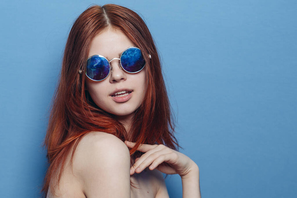 perky red-haired woman in blue glasses bare shoulders posing - Фото, зображення