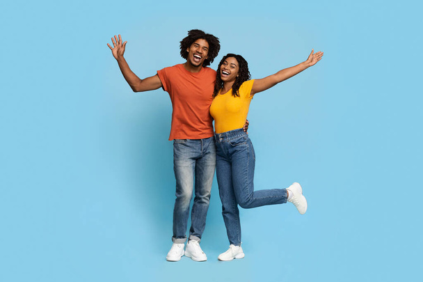 Happy african american lovers embracing over blue studio background - Foto, Bild