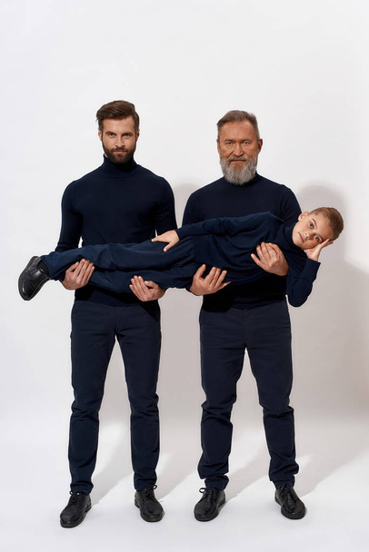 Portrait of three generations of men pose in studio - Photo, Image