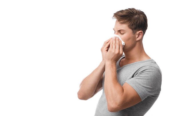 インフルエンザや風邪の最初の症状に苦しんで千年の魅力的な白人男性,鼻水,吹く,体調不良 - 写真・画像