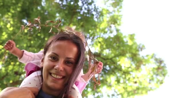 Portrait of a young mother with baby on hands at the park. Young mother with baby in a city park.Mother playing with baby in the park on the grass.Mom with a little girl in nature. - Footage, Video