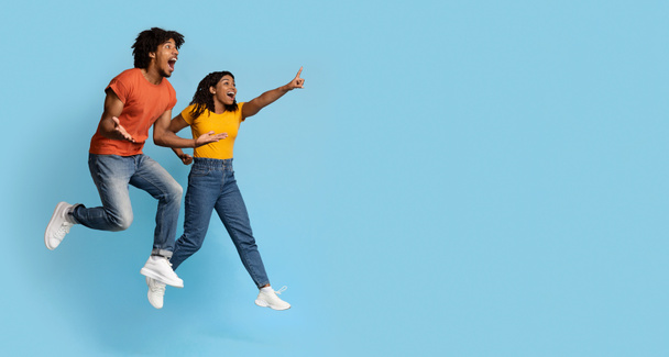 Безтурботний молодий чорний чоловік і жінка стрибають у повітрі
 - Фото, зображення