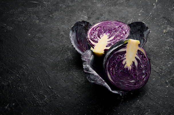 Fresh cabbage. Fresh sliced purple cabbage. On a black stone background. - Foto, Imagen
