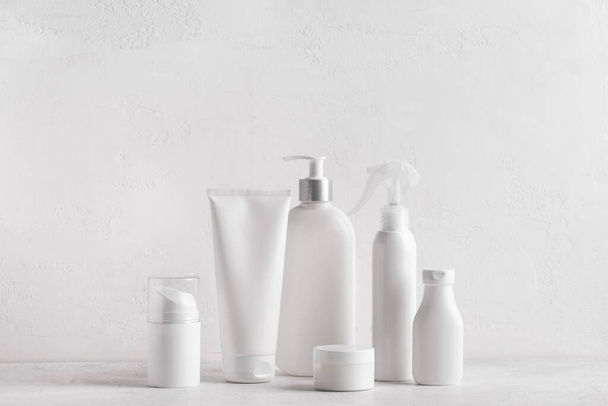 White jars, tubes and bottles cosmetic containers on white background, copy space. Bath skin care accessories. Face and body care concept. - Φωτογραφία, εικόνα