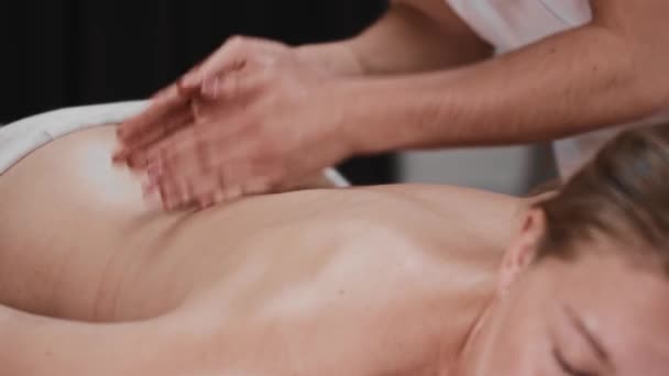 Sesja masażu - masażystka klepie się po plecach krawędzią dłoni - Materiał filmowy, wideo