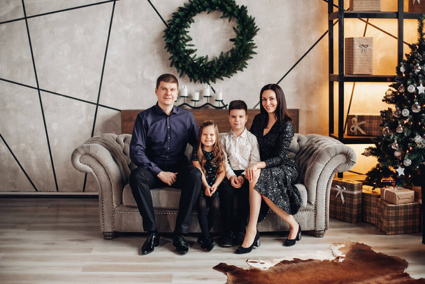 Hermosa familia con dos hijos en sofa.at Navidad. - Foto, imagen