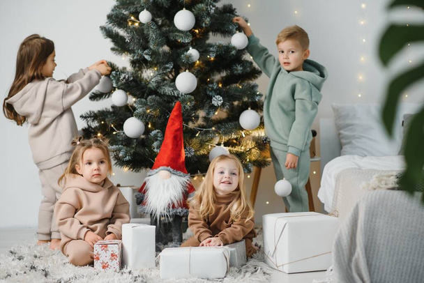 Kinder unterm Weihnachtsbaum mit Geschenken und Spielzeug - Foto, Bild