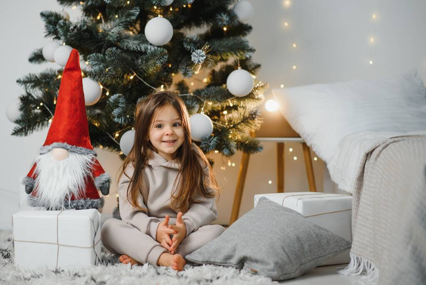 Happy little smiling girl with christmas gift box. - Valokuva, kuva