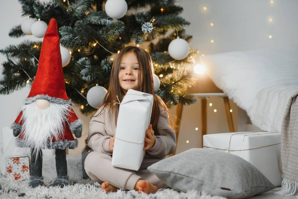 Happy little smiling girl with christmas gift box. - Foto, Imagen
