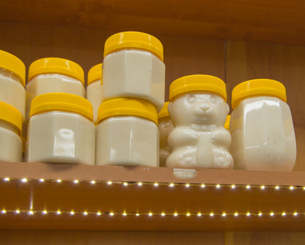 Φυσικό μέλι σε διάφορα βάζα σε ξύλινο ράφι, σουβενίρ στην αγορά του χωριού. - Φωτογραφία, εικόνα