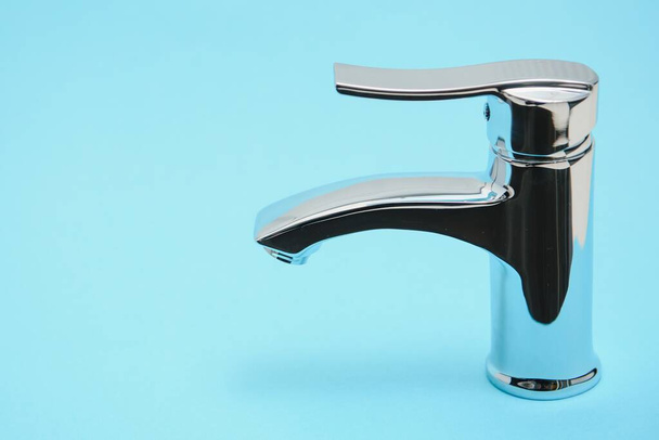 Single handle water tap on light blue background, closeup - Foto, immagini