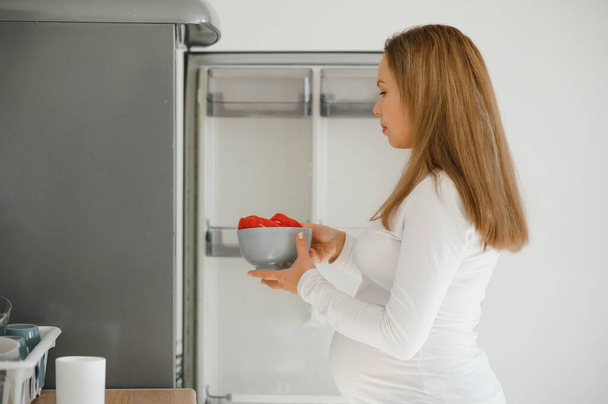 Terhes nő a konyhában, hogy saláta - Fotó, kép