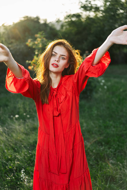 attractive woman in red dress outdoors in freedom field - 写真・画像
